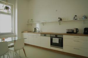 a kitchen with white cabinets and a table and a window at Apartment Edda in Senftenberg +16 photos
