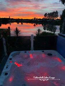 a hot tub with red lights in front of a lake at Meridian Tattershall Lakes Escape - Lakeside lodge caravan with a fishing peg LUXURY HOT TUB in Tattershall