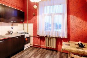 モスクワにあるApartment Galushkina 17の赤い壁のキッチン、テーブル、窓