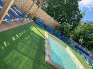a swimming pool with blue chairs in a yard at THITOME in Limeuil