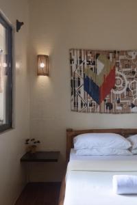 長灘島的住宿－懶漢食宿酒店，一间卧室设有两张床,墙上挂着一幅画