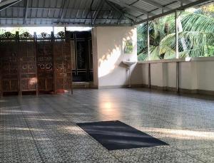 um quarto vazio com um quarto com portas e um tapete em Villa Anandha em Trivandrum
