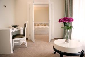 a room with a table and a vase of purple flowers at Noorus SPA Hotel in Narva-Jõesuu