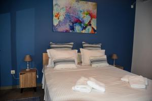 una camera blu con un grande letto con asciugamani di Velvet new apt in Ilissia ad Atene