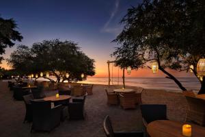 - un restaurant sur la plage avec des tables et des chaises dans l'établissement Jambuluwuk Oceano Gili Trawangan, à Gili Trawangan