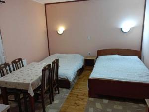 a room with two beds and a table and chairs at Apartments Vukomanović in Zlatibor