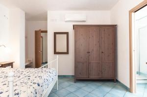 スペルロンガにあるRelais Sperlonga Apartmentのベッドルーム1室(木製ワードローブ、ベッド1台付)