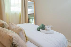 a white bed with two towels and a mirror at Exquisite Villa - Elegant Living in Dubai
