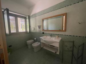 a bathroom with a sink and a toilet and a mirror at Santa Pigna in Centola