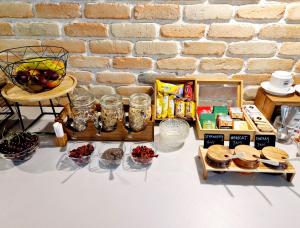 a table with food and desserts on it in front of a brick wall at Atlantic Boutique in Târgu-Mureş