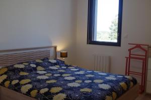 1 dormitorio con 1 cama con edredón azul y ventana en Trébeurden appartement T 3 vue mer 3 ***, en Trébeurden