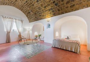 a bedroom with a bed and a table with a chair at Tenuta Bukkuram in Pantelleria