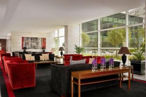 ポルトにあるシェラトン ポルト ホテル & スパのロビー(ソファ、赤い椅子、テーブル付)