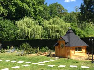 a small wooden dog house in a garden at Les Roulottes De La Basse Maunerie in Les Herbiers