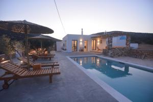 アンティパロス島にあるKtima Elea Antiparosのベンチとパラソル付きのプール、家