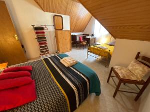 1 dormitorio con 1 cama y 1 silla en una habitación en la vallee en Plogoff