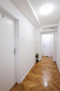 pusty korytarz z białymi ścianami i drewnianą podłogą w obiekcie ClickTheFlat Muranów Apart Rooms w Warszawie