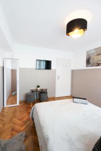 sypialnia z dużym białym łóżkiem i lustrem w obiekcie ClickTheFlat Muranów Apart Rooms w Warszawie