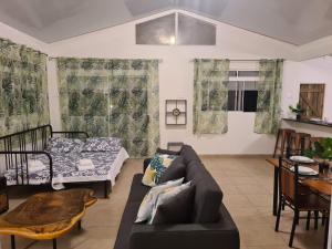 a living room with a couch and a table at Taharu'u Guest House By The Beach in Papara