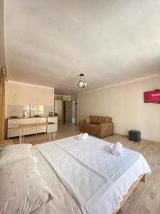 夏克班提維的住宿－Panorama Bajo Shekvetili，一张大白色的床,位于一个配有沙发的房间