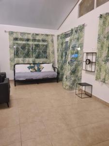 een kamer met een bed en twee ramen met gordijnen bij Taharu'u Guest House By The Beach in Papara
