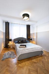sypialnia z dużym łóżkiem i dużym oknem w obiekcie ClickTheFlat Muranów Apart Rooms w Warszawie