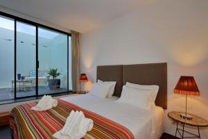 een slaapkamer met een bed en een groot raam bij Vila D`Obidos in Casal da Lagoa Seca +21 foto's