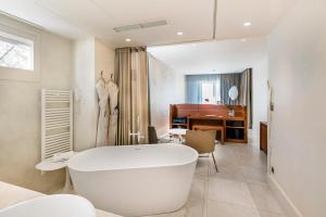 a white bath tub in a bathroom with a piano at Le Petit Nice - Passedat in Marseille