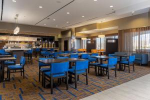 a dining room with blue chairs and tables at Courtyard by Marriott Asheville Airport in Arden