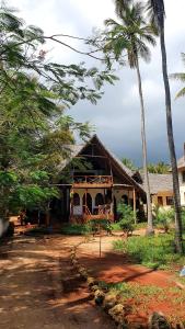 una casa con palme di fronte di Lazy Beach House a Kiwengwa