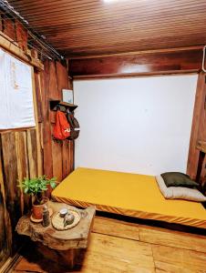 a bedroom with a yellow bed and a table at The GK House Hostel, Ecolliving, central city, natural wooden, chill view rooftop, reétaurant and cocktail bar in Ho Chi Minh City