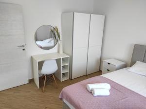 a bedroom with a bed and a mirror and a desk at Apartman Smokva in Kumbor