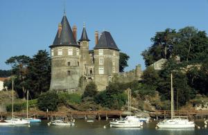un château sur une colline avec des bateaux dans l'eau dans l'établissement Maison de ville pour 7 dans la ville haute de Pornic, à Pornic