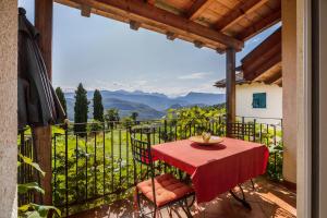 a red table and chairs on a balcony with a view at Weingut Lieselehof Apt Rosengarten in Caldaro
