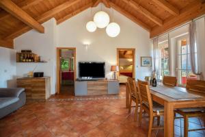 a living room with a table and a tv at Weingut Lieselehof Apt Rosengarten in Caldaro