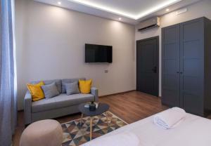 ein Wohnzimmer mit einem Sofa und einem TV in der Unterkunft Hotel Nacional in Bosanska Gradiška