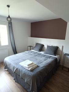 sypialnia z dużym łóżkiem i niebieskim kocem w obiekcie A l'Ombre des Bois, Chambre Quadruple Confort w mieście Neung-sur-Beuvron