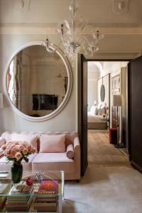 ein Wohnzimmer mit einem rosa Sofa und einem Spiegel in der Unterkunft Nolinski Venezia - Evok Collection in Venedig