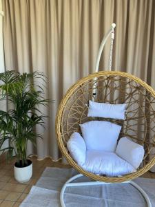 una silla colgante con almohadas blancas en una habitación en Perla Beach Stabia B&B, en Castellammare di Stabia