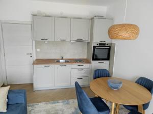 a kitchen with a table and chairs and a sink at Apartman Smokva in Kumbor