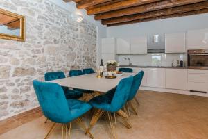 een keuken en eetkamer met een tafel en blauwe stoelen bij Old Zaton in Zaton