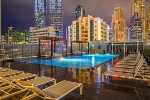 basen z leżakami i panoramą miasta w obiekcie Astonishing Marina & sea view modern apartment w Dubaju