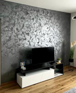 sala de estar con TV de pantalla plana en la pared en Apartman Star #1 en Vinkovci
