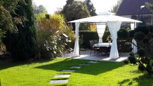 a white gazebo with a table in a garden at Falkenapartment Berlin in Berlin