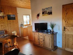 sala de estar con TV en un armario de madera en Gästehaus Josefine en Lam