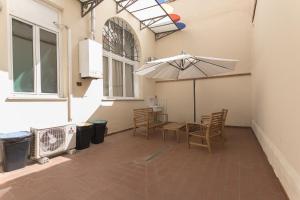 een patio met een tafel en stoelen en een parasol bij Amalia Apartment Via La Farina in Florence