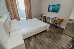 pokój hotelowy z łóżkiem i stołem w obiekcie Alliance Palace Aparthotel w mieście Batumi