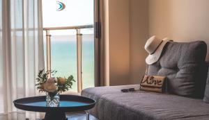 een woonkamer met een bank, een tafel en een raam bij Daniel Herzliya Hotel in Herzelia 