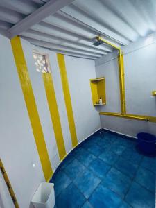 a room with yellow and white stripes on the walls at Endless Blue Hostel 