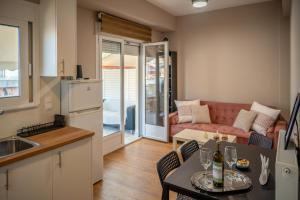 a kitchen and living room with a table and a couch at Acropolis Terrace View Apartment in Athens